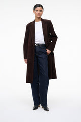 Black ankle sock boots worn with a long dark coat and jeans.