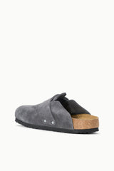 A single gray suede clog slipper with a black sole and a natural cork footbed, shown from a side profile against a plain white background.