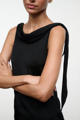 Black sleeveless top with cowl neck and draped one-shoulder tie