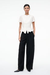 Ivory peplum top with short sleeves and center-front zipper, asymmetric hem