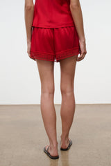 Tomato red silk short with lace-trim hem and tiered ruffle look
