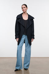Black open-front jacket with relaxed lapels and buttoned shoulder straps