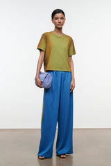 Blue wide-leg pants with elastic waistband and yellow side stripe, flowing drape