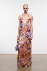 Sleeveless scoop-neck maxi dress with flowing hem; orange and purple abstract print.