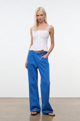 White sleeveless corset-style top with lace trim and structured seams