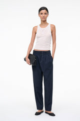 Ivory ribbed tank top with small front embroidery, worn as racerback