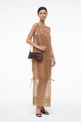 Dark brown croc-textured clutch with long strap, carried across front