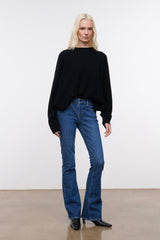 Stone blue denim flare jeans on model, mid-rise with wide-leg straight fit