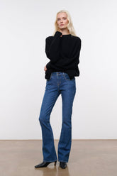Stone blue denim flare jeans on model, mid-rise straight wide-leg silhouette