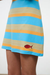 Striped tank dress in blue, tan, and yellow with red fish logo at hem