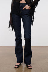 Indigo stretch flare jeans on model with high-rise fit and stitched front seams