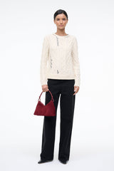 Burgundy suede shoulder bag with short handles, held at the side