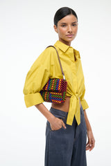 Multicolor beaded shoulder bag worn over yellow shirt with brown strap