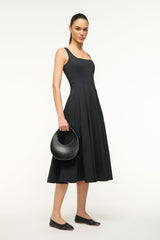 Black mini moon bag worn across front on shoulder strap