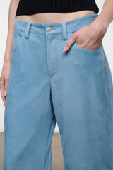 Sky blue suede pants with button closure, belt loops, and front slash pockets.