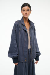 Dark blue chambray jacket with wide sleeves, snap-button front, and shoulder tabs