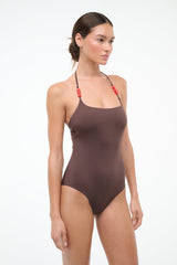 Dark brown halter one-piece swimsuit with red beaded straps, side profile
