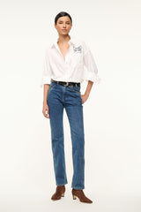 White oversized button-up shirt with chest pocket and cat graphic patch