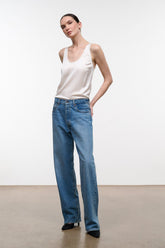 Medium-wash boyfriend jeans with relaxed fit, wide legs, and button waist
