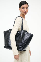 Black croc-effect leather tote bag with curved top handles and roomy size.