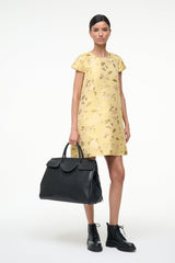 Black carryall handbag with top handles, carried by model at front