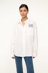 White oversized button-up shirt with cat graphic patch on chest pocket