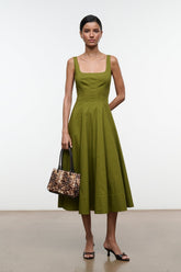 Wells dress, olive green sleeveless midi A-line with square neckline; holding handbag