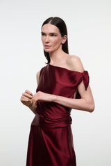 Deep burgundy silk midi dress with off-shoulder neckline and gathered bow at shoulder
