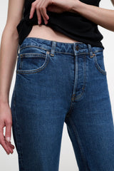 Stone blue denim jeans waistband close-up with button closure and stitched pockets