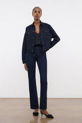 Indigo denim jacket on model, side view with button front and flap chest pockets