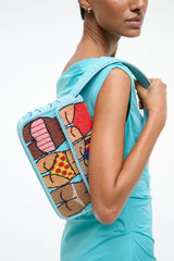 TOMMY beaded beach bag side view worn on model, turquoise with colorful block design