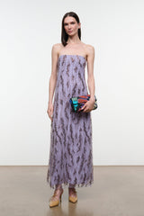 Lilac strapless maxi dress with black speckled print, holding small clutch