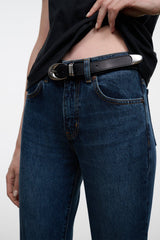 Indigo denim jeans close-up with belt, metal buckle, and buttoned waistband