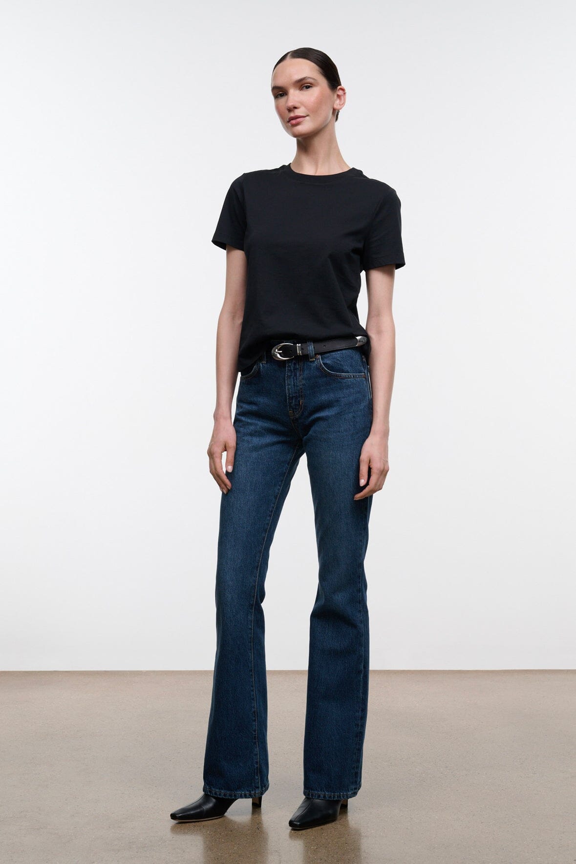Dark indigo flare jeans with belt loops, button-zip front, and straight-to-flare legs