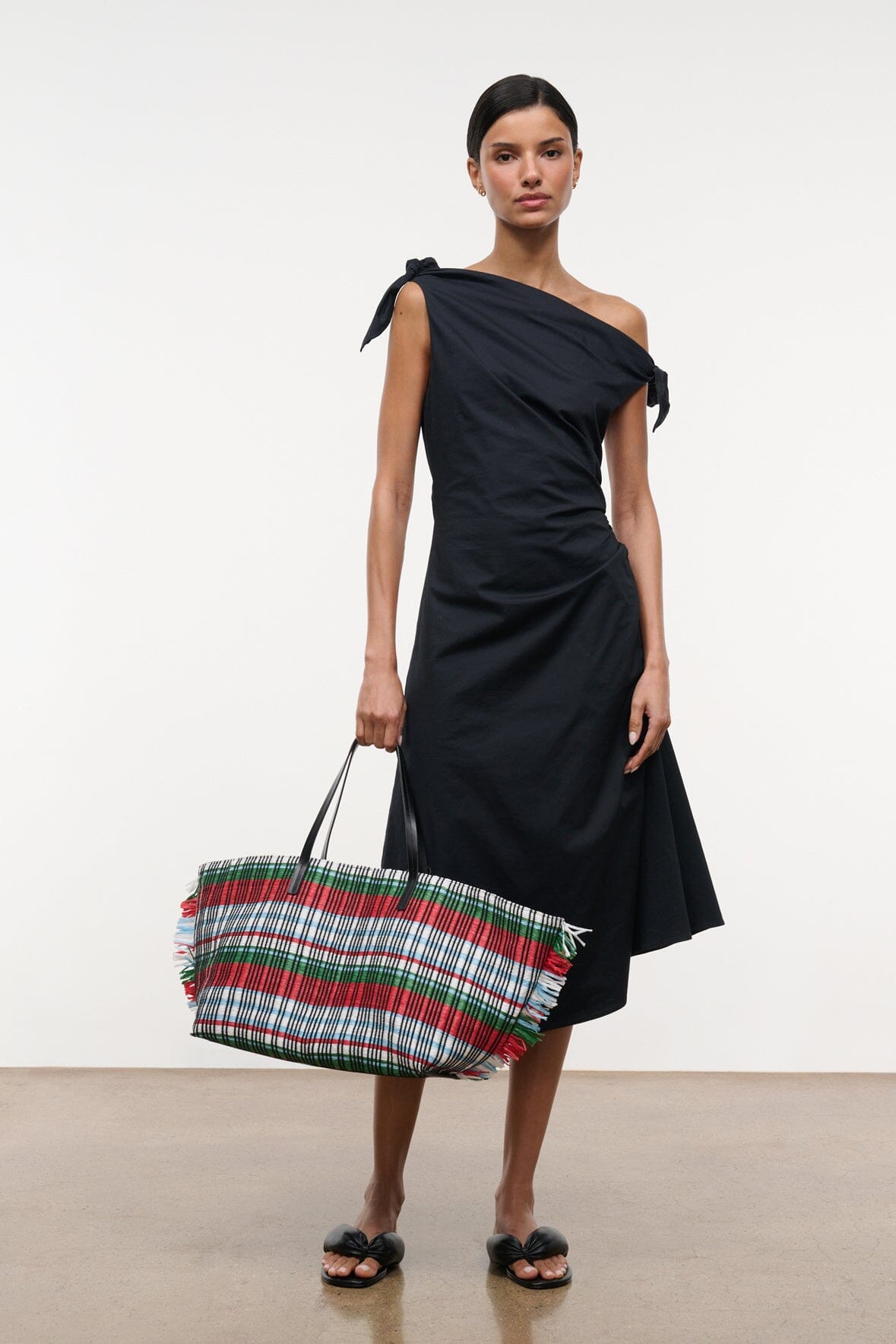 Black one-shoulder midi dress with tied shoulder bow and gathered side detail