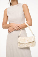 Cream woven crossbody shoulder bag with flap and metal hardware