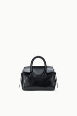 Maude mini carryall bag with structured body, curved handle, and dangling tassels