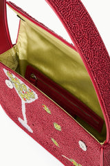 Interior view of red beaded handbag showing open top, fabric lining, and zip pocket