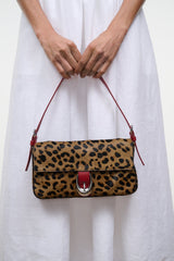 Cheetah-print bag with top flap and red straps, front close-up