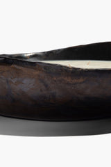 Dark brown ceramic candle bowl with molded texture and white wax rim