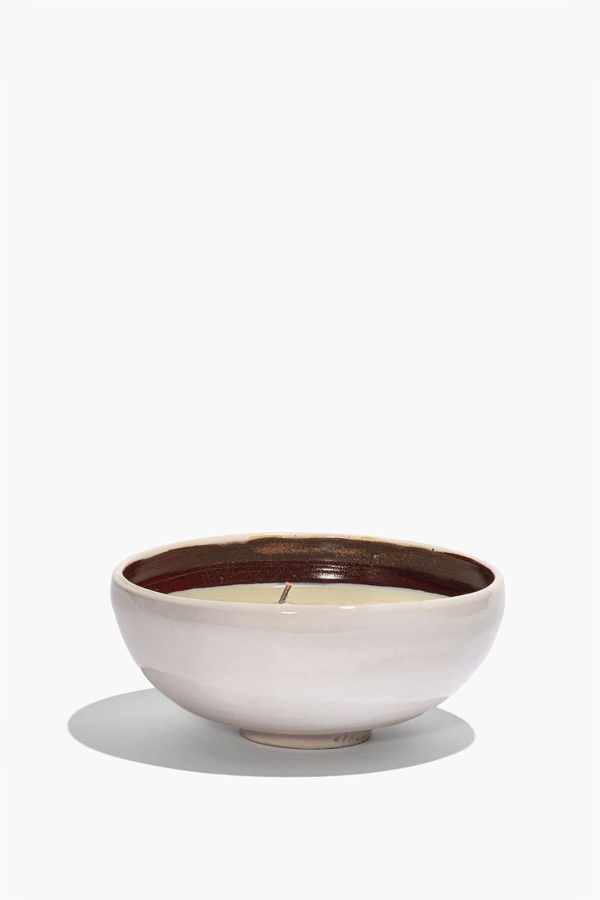 Large ceramic candle in white ceramic bowl with cream wax and centered wick