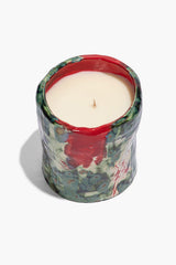 Medium ceramic candle with off-white wax center and red rim on patterned base