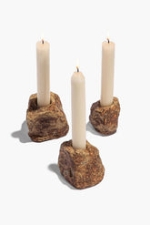 Organic rock candlestick set with three white candles in rugged stone holders
