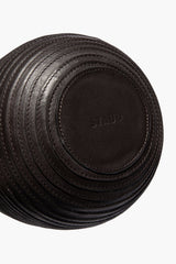 Wrapped vase bottom with stitched circular detailing and embossed logo patch