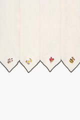 Natural embroidered napkins with black-trimmed edges and colorful corner motifs