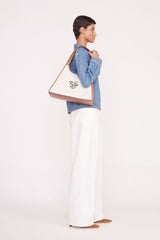 Cream canvas tote bag with tan leather handles and side edge seam