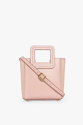 Blush leather mini tote bag with adjustable crossbody strap and gold buckle