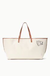 Cream canvas tote bag with tan leather handles and dog-face logo patch