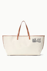 Cream canvas tote bag with tan leather handles and two dog-face illustrations