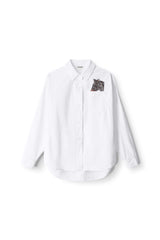 White oversized button-up shirt with long sleeves and chest patch graphic